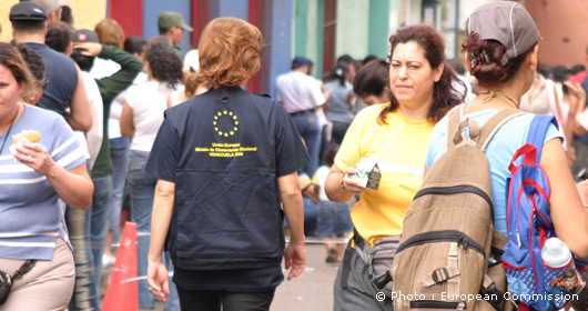EUEOM - EU election observer walking amongst queuing people