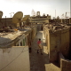 In Garden City, a tiny village that grew under the dish antennas. On each side of the straight alleys, families occupy one or several rooms in the huts formerly used to do the laundry.