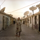 In Garden City, a tiny village that grew under the dish antennas. On each side of the straight alleys, families occupy one or several rooms in the huts formerly used to do the laundry.