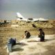 Near the Omar Museum, a man does his first prayer in front of a plane wreck.