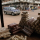 A sports-utility vehicle, one of many in the capital, drives past decaying colonial buildings and a market stall in central Bissau. According to police there are several Hummers in the capital &mdash; a car worth more than 100 times the average annual salary. 