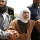 Nahr el Bared, 26 May 2007. An elderly Palestinian woman is supported as she crosses a Lebanese army checkpoint while fleeing the besieged camp.