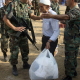Nahr el Bared, 10 October 2007. Lebanese soldiers search a Palestinian refugee before he enters camp. Dozens of Palestinian families returned in buses and mini-vans hired by the UN Relief and Works Agency with just a few personal items.