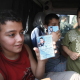 Nahr el Bared, 10 October 2007. Palestinian refugee children show their identity cards as they wait for Lebanese soldiers to search their belongings before they enter the bombed-out Nahr el Bared refugee camp.