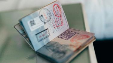 A passport filled with stamps sits open