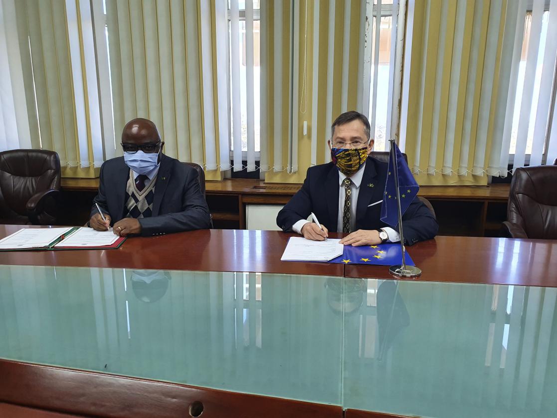 Two men signing documents