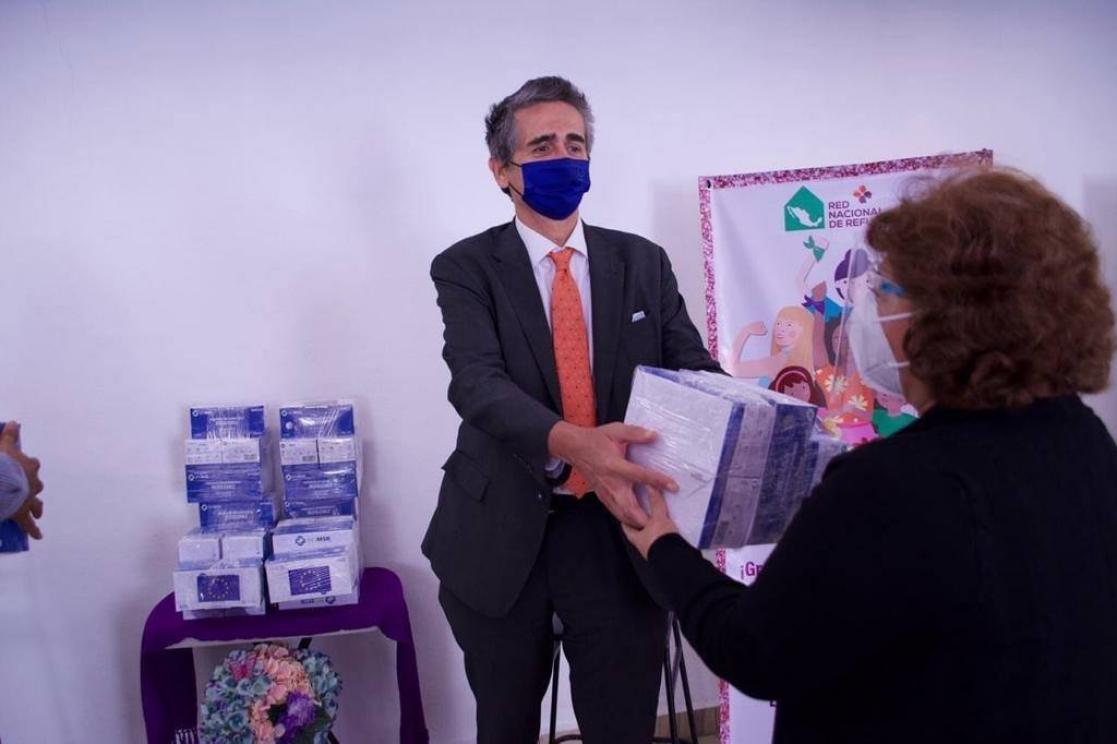 Man gives a woman a packet of face masks
