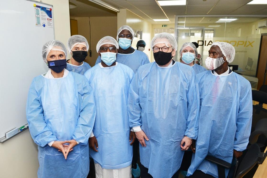 Group of people wearing a lab coat, mask and hair net during a visit to a laboratory