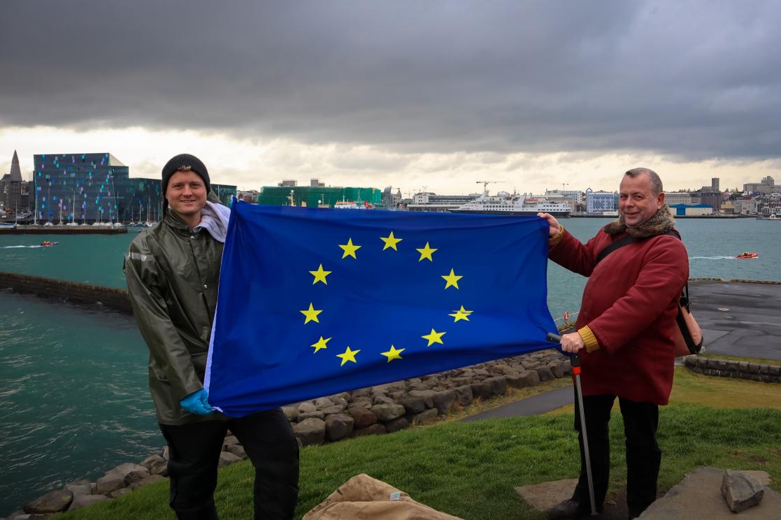 Two men posing with the European Union flag