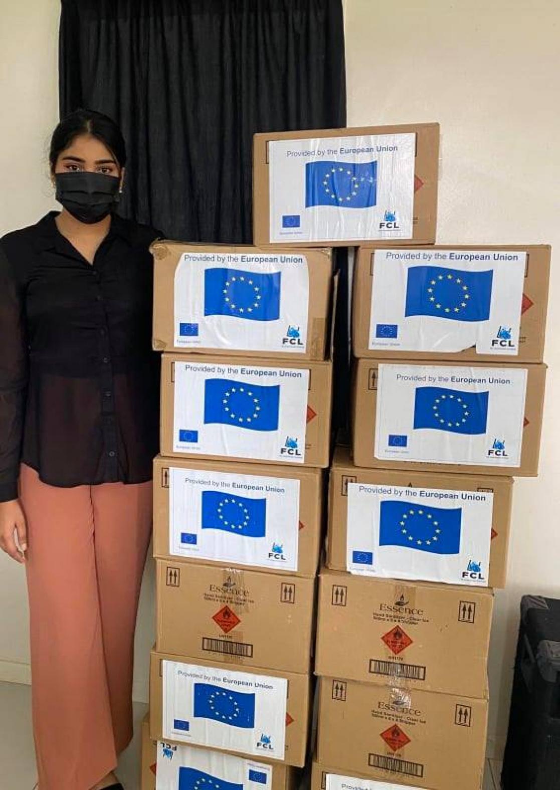 Woman posing with boxes of material