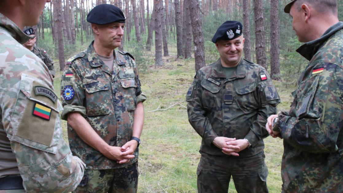 Infantry commanders in a wooded area in conference.