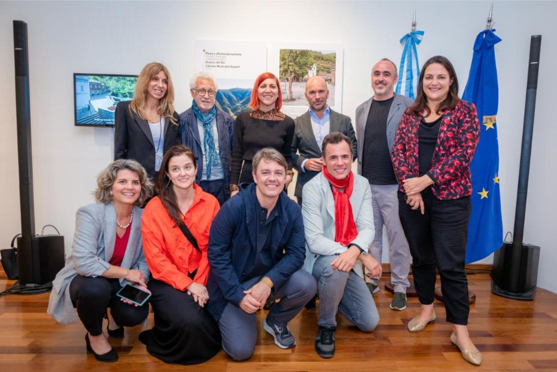 A group of 10 people pose for a photo, smiling.