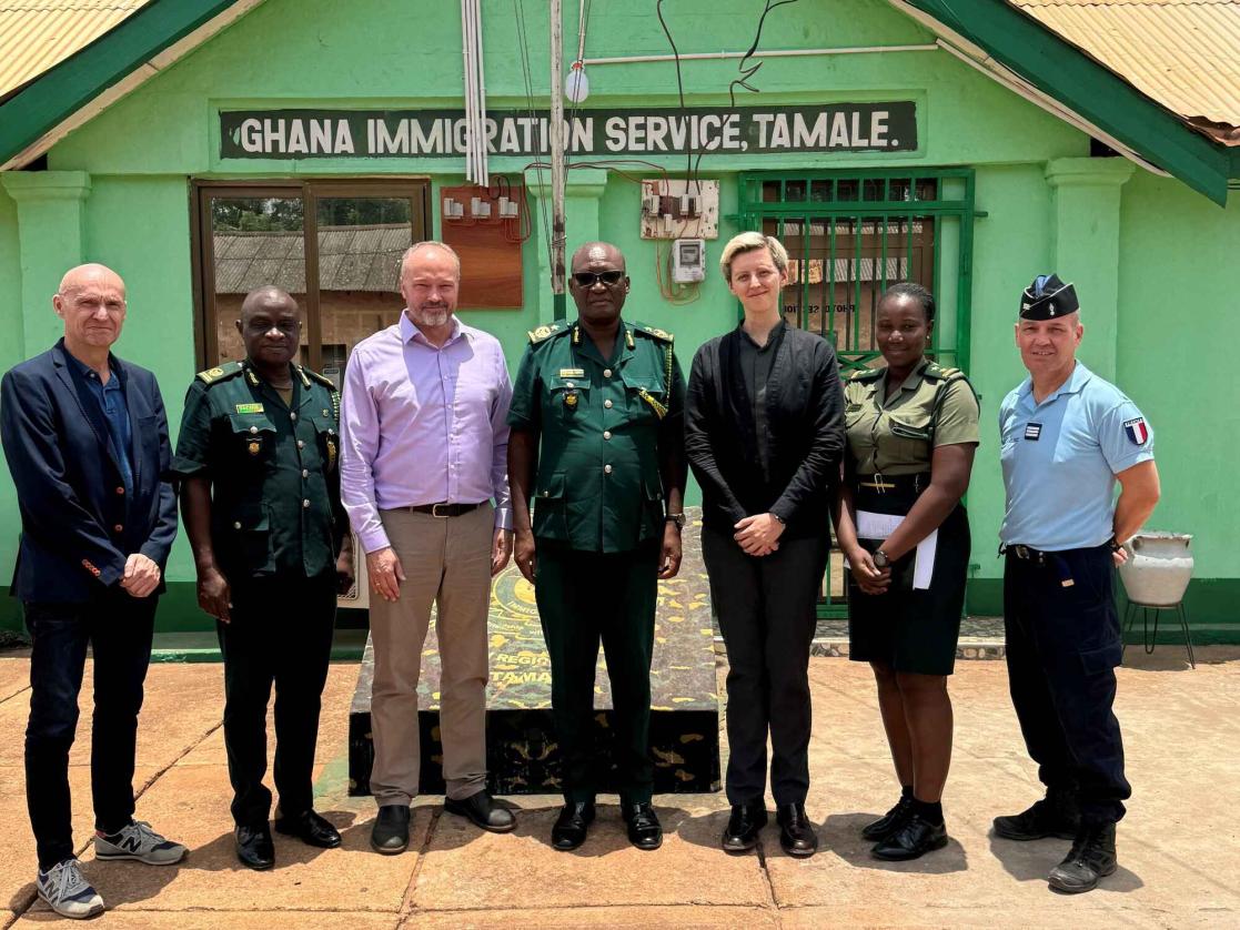 Seven individials pose at the Ghanian border for a security mission visit. 