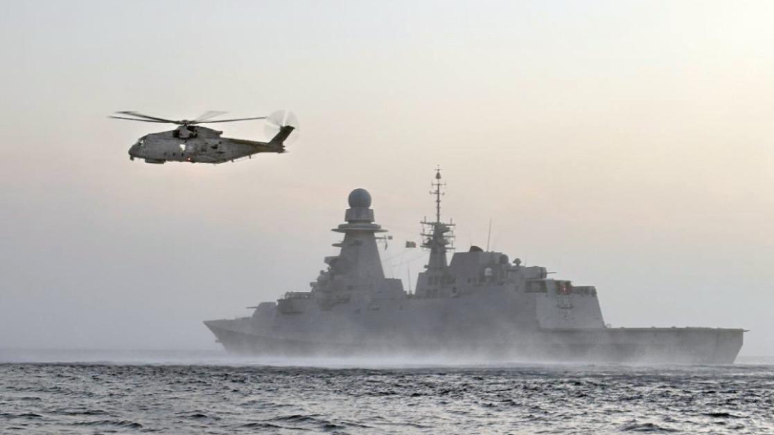 Helicopter and naval ship on operations at sea.