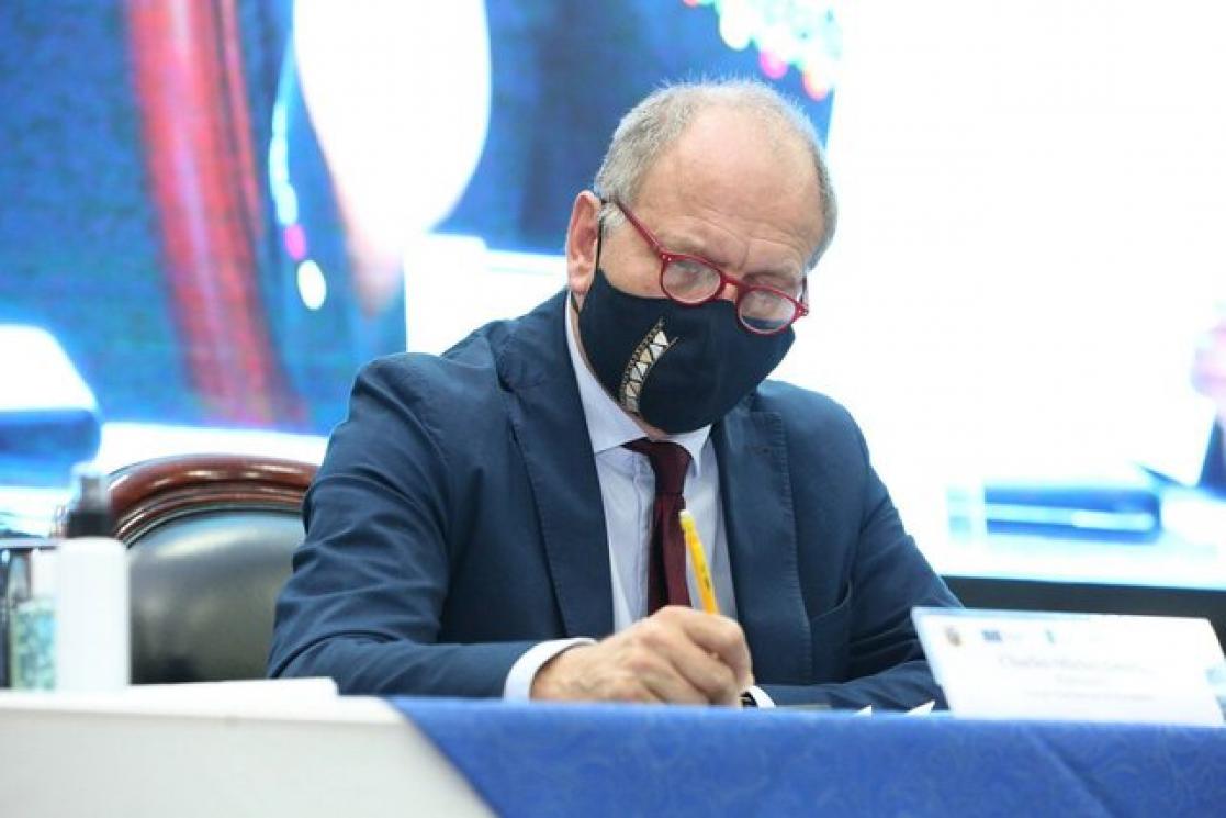 Man with red glasses and face mask writing