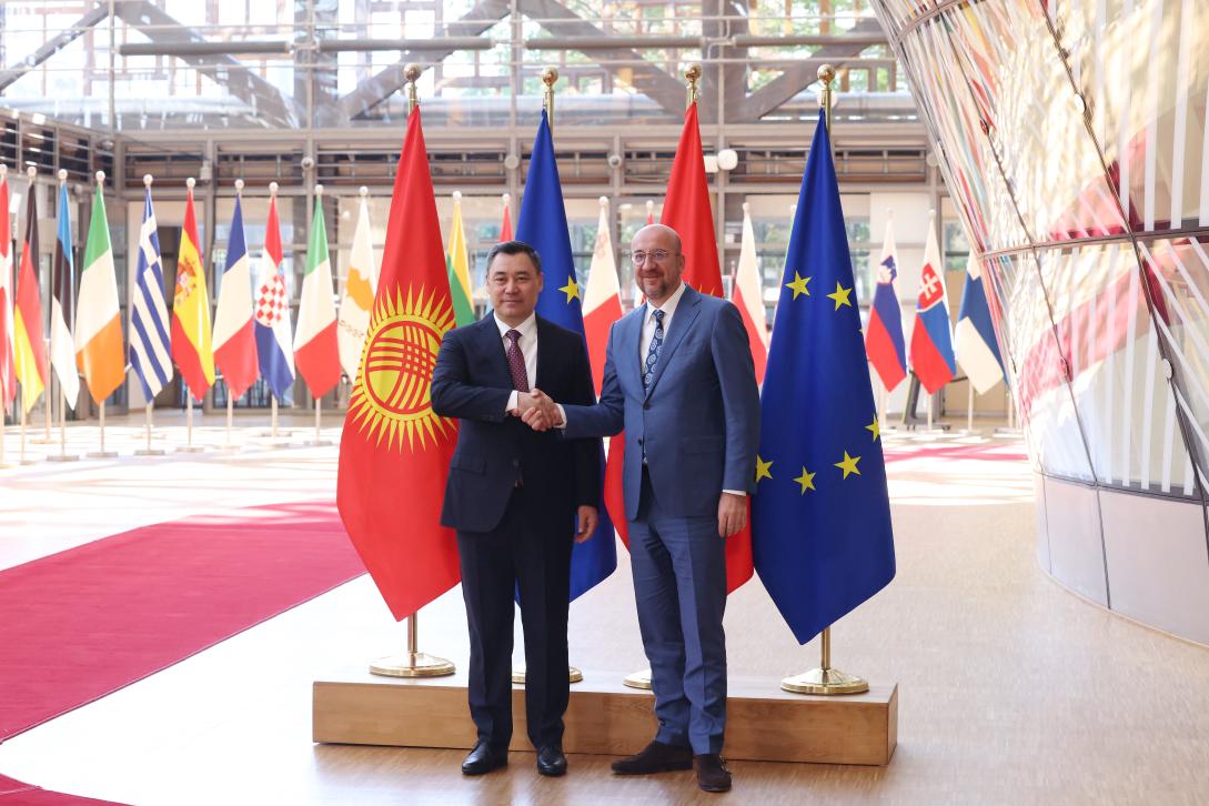 Kyrgyz Republic and EU representatives are standing in front of the Kyrgyz and EU flags