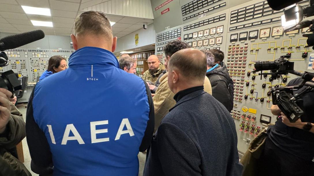 Official crowd a control room in a nuclear power plant.