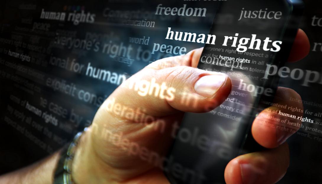 Hand holding internet device with Human Rights highlighted