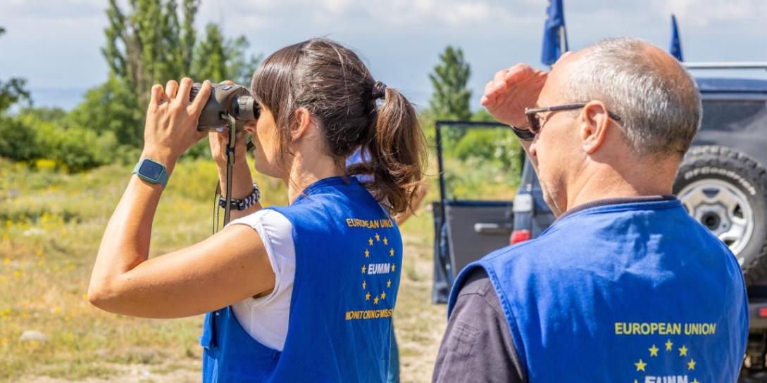 Picture of EUMM colleagues observing the field. Woman on the lead