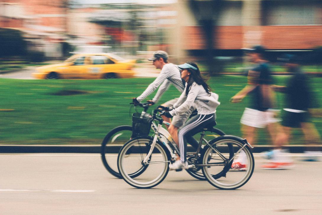 Man and a woman riding bikes on the street