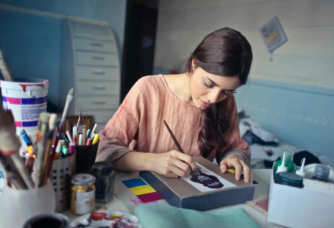 Female artist sittinf and working on a picture