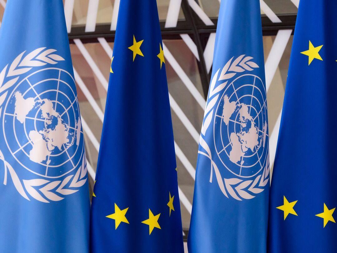 UN and EU flags side-by-side.