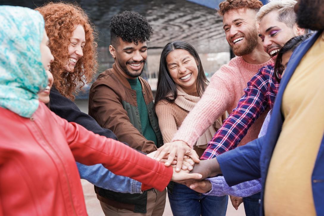 Group of young multiracial people stacking hands (Envato)