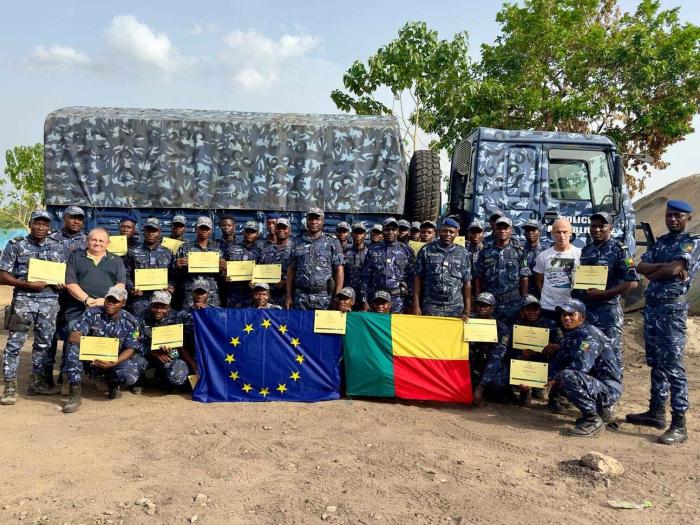 Another family photo with a truck in background, EU and Benin flags. 