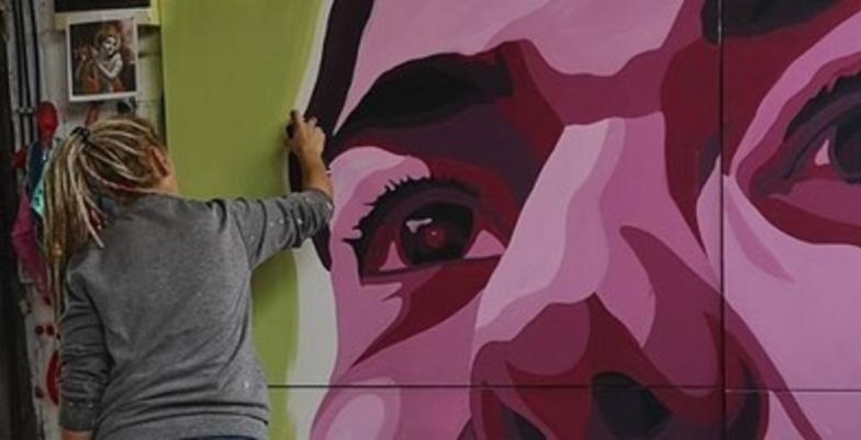 Woman drawing mural - promoting empowered women in Serbia