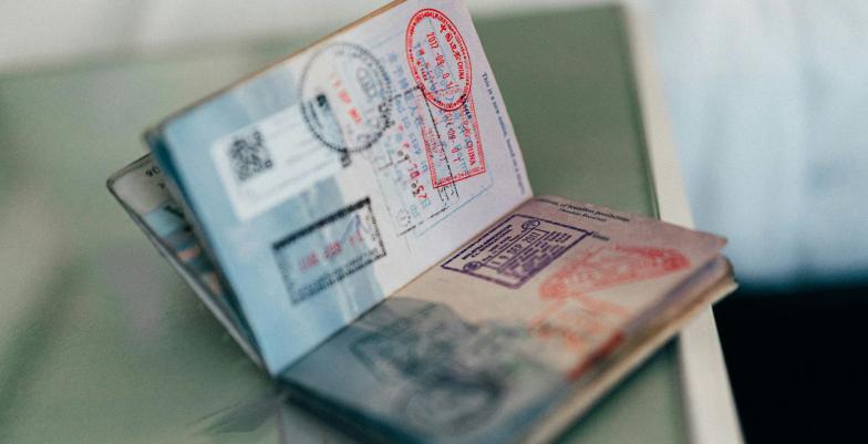 A passport filled with stamps sits open
