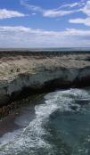 Un paisaje costero con el mar rompiendo en las rocas.